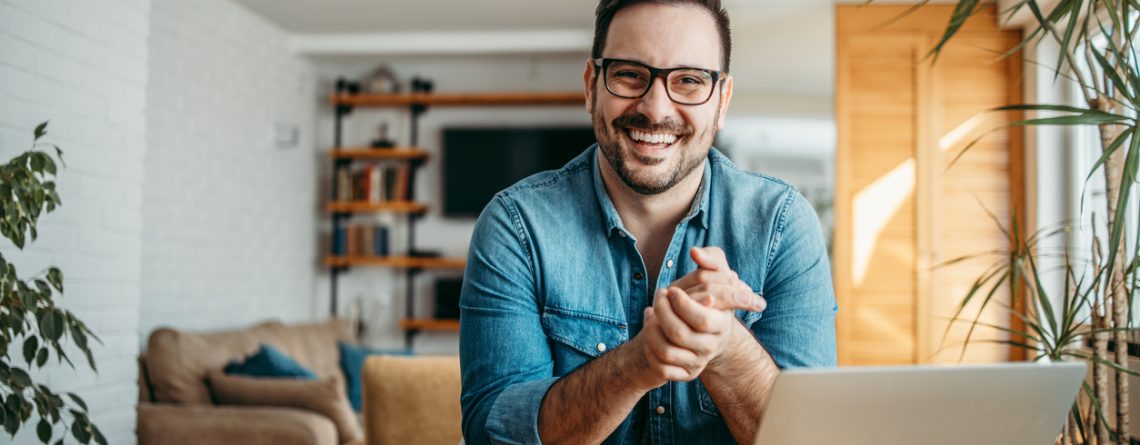 successful entrepreneur at cozy home office, smiling at camera.