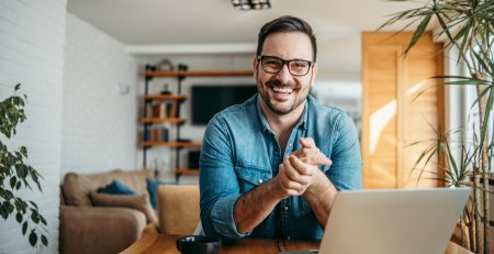 successful entrepreneur at cozy home office, smiling at camera.