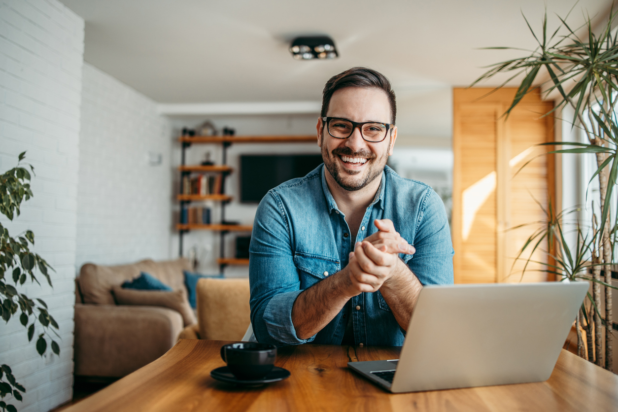 successful entrepreneur at cozy home office, smiling at camera.